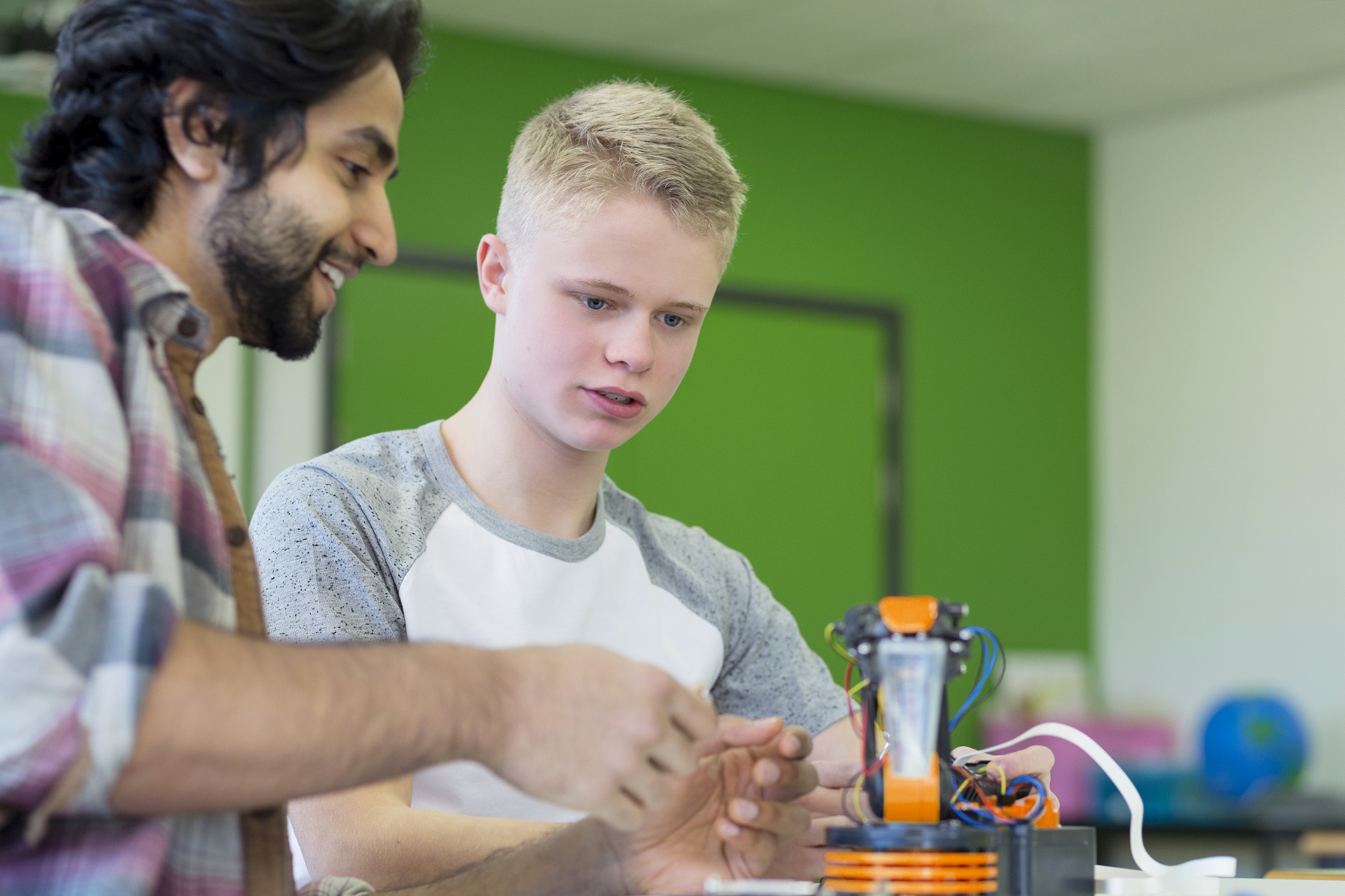 Teacher and student building a robotic arm