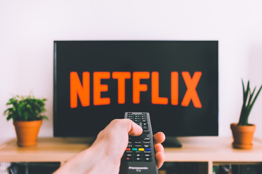 person using a remote to streaming netflix