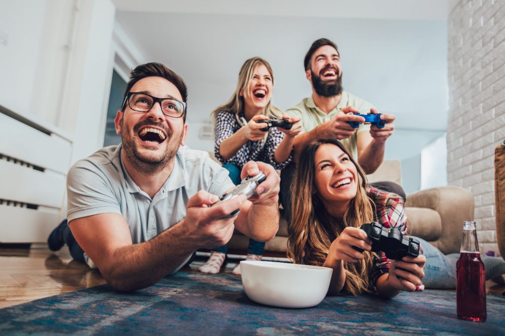 group of friends play video games together at home