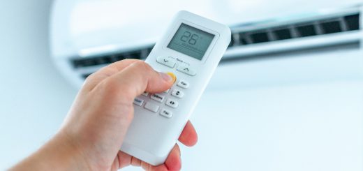 Air conditioner temperature adjustment with remote controller in room at home