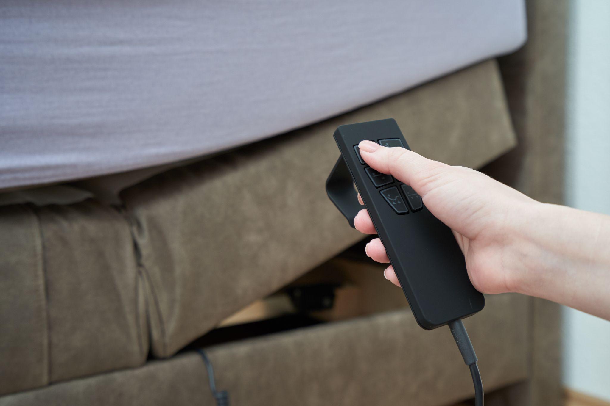 Hand using an adjustable bed remote